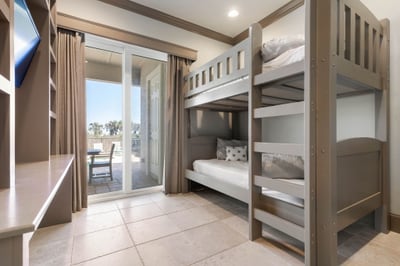 Sunlight spills through the doors as kids race in from the patio, sandy feet and smiles, claiming their bunks after another perfect day.