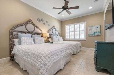 With two inviting beds, coastal colors, and a warm glow at day's end, this cheerful bedroom is made for cousins, sisters, or friends to unwind together.