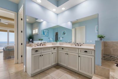 Morning light spills across the vanity while the ocean waits just beyond the bedroom, and suddenly getting ready feels like part of the vacation.