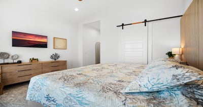 A serene coastal retreat featuring a plush bed, warm wood accents, and a modern barn door—clean lines, soft textures, and a calm, airy feel designed for…